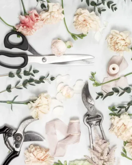 A bunch of flowers and scissors are prepped on a table for a custom workshop at the TAKAYASATO.COM Flower School.