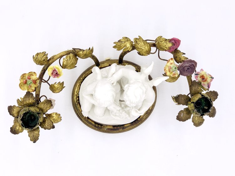 A pair of TAKAYASATO.COM candle holders with angels and birds on them