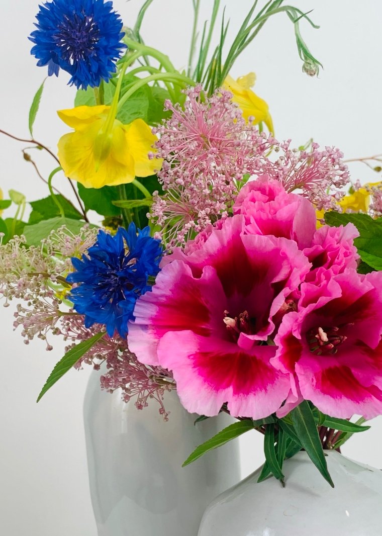Two white vases with a Takayasato.com COLORFUL flower arrangement.