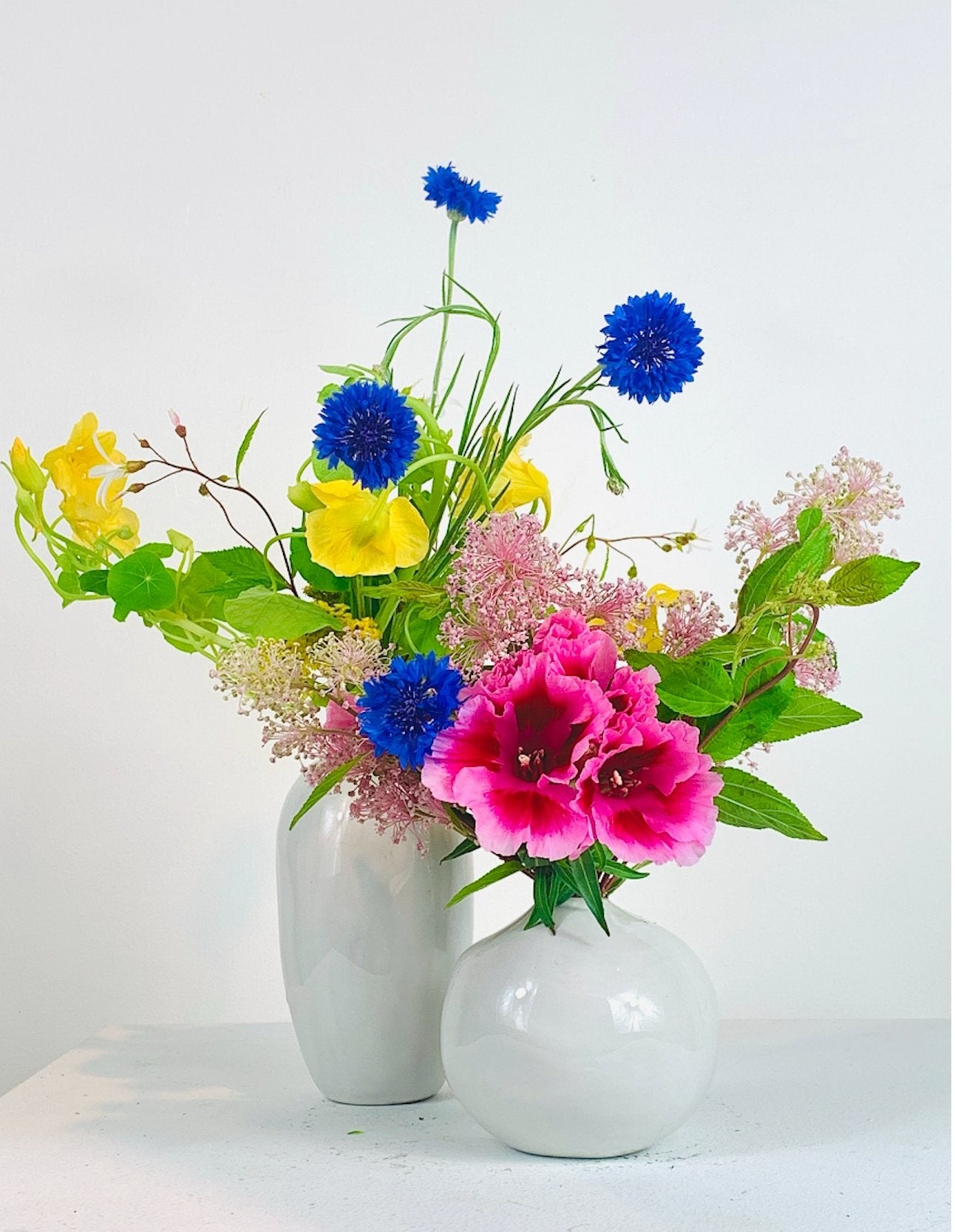 Two white vases with a Floral COLORFUL arrangement from TAKAYASATO.COM.