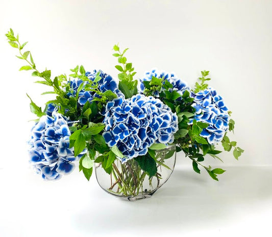 Blue MONOFLOWER hydrangeas arranged in a glass vase from TAKAYASATO.COM exude an elegant presence.