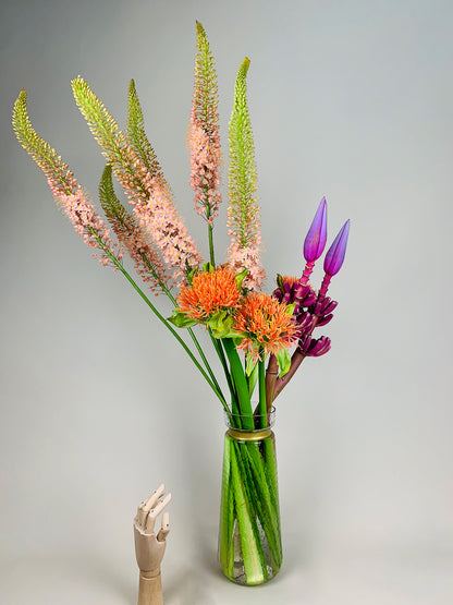 An arrangement of COLORFUL flowers in a vase with a mannequin by TAKAYASATO.COM.