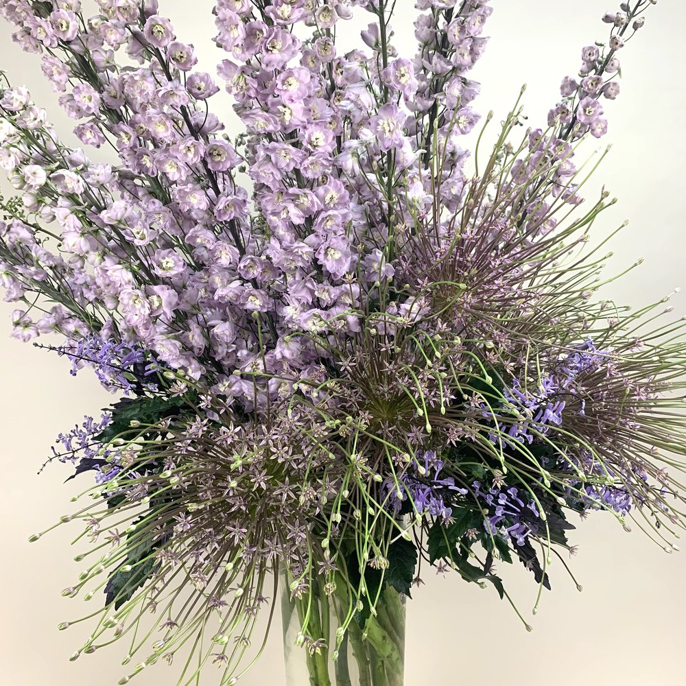 An arrangement of ECCENTRIC purple flowers in a vase showcasing botanicals from TAKAYASATO.COM.