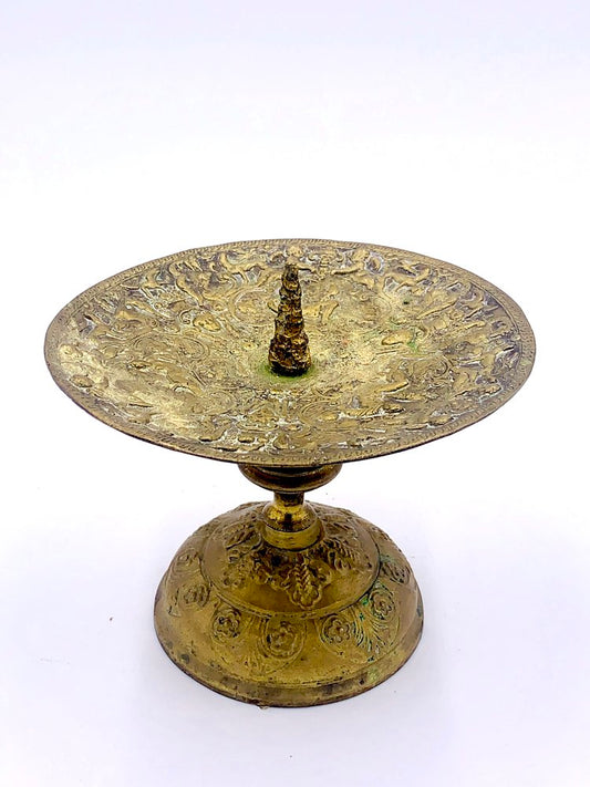 A brass candle holder on a stand from TAKAYASATO.COM.