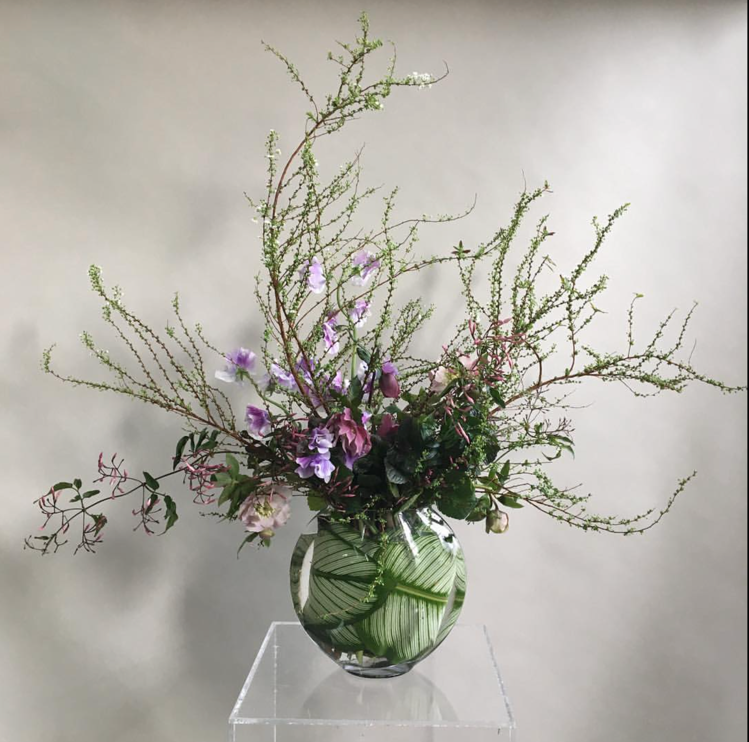 A botanical arrangement of ECCENTRIC flowers and greenery in a vase from TAKAYASATO.COM.