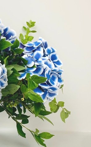 A single blue and white MONOFLOWER in a vase on a table adds an elegant presence to the room from TAKAYASATO.COM.