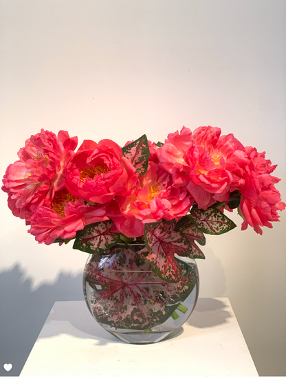 Pink MONOFLOWER peonies in a glass vase from TAKAYASATO.COM create an elegant presence on a table.