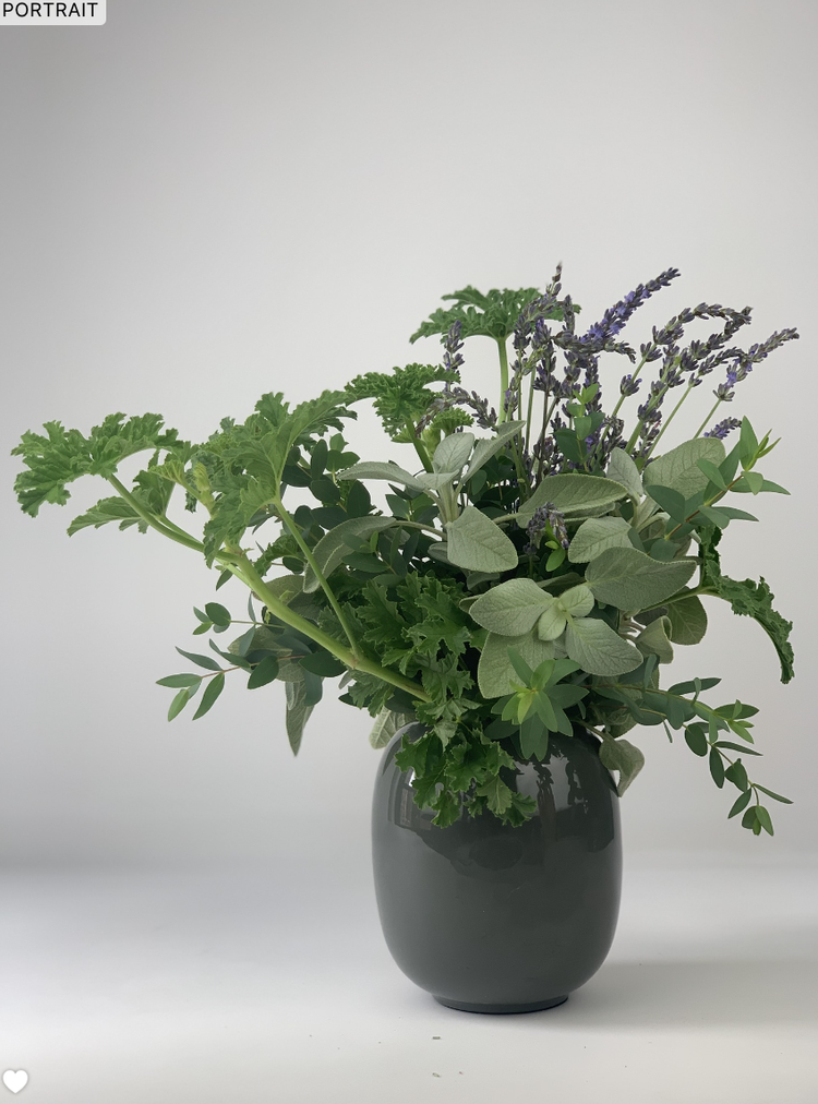 A WHITE,GREEN & HERBS vase from TAKAYASATO.COM with a bunch of flowers in it.