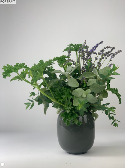 A WHITE,GREEN & HERBS vase from TAKAYASATO.COM with a bunch of flowers in it.