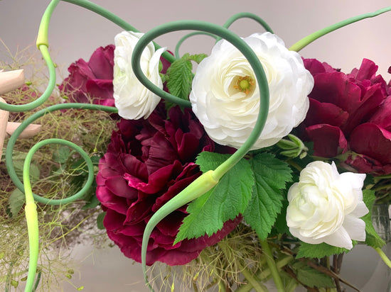 A vase filled with red and white flowers.