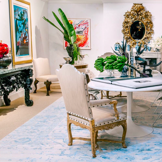 An ornate room with a large table and chairs that has floral decorations.