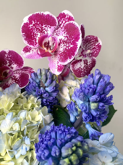 Floral bouquet with blue hydrangeas and pink orchids.