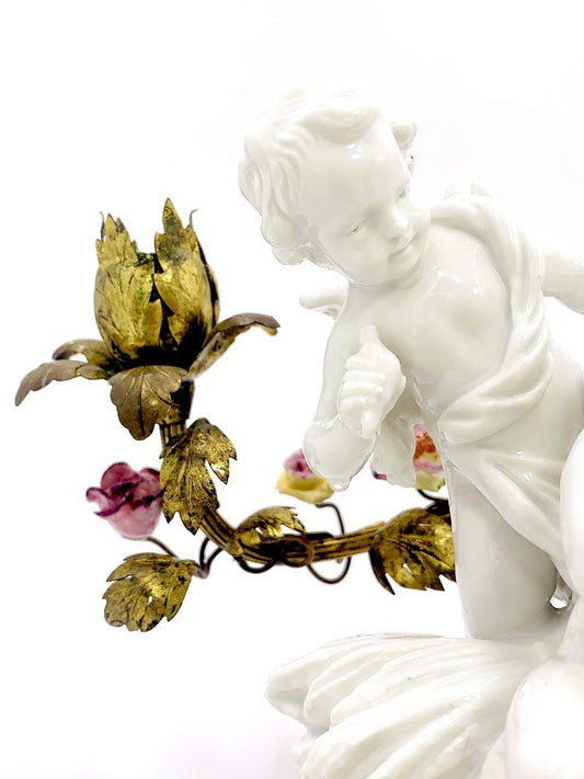 A white porcelain figurine of a cherub holding a flower candle holder by TAKAYASATO.COM. Angels with the cage. Porcelain and brass.