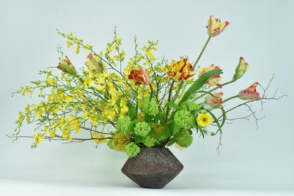 A COLORFUL vase filled with bright yellow flowers from TAKAYASATO.COM.