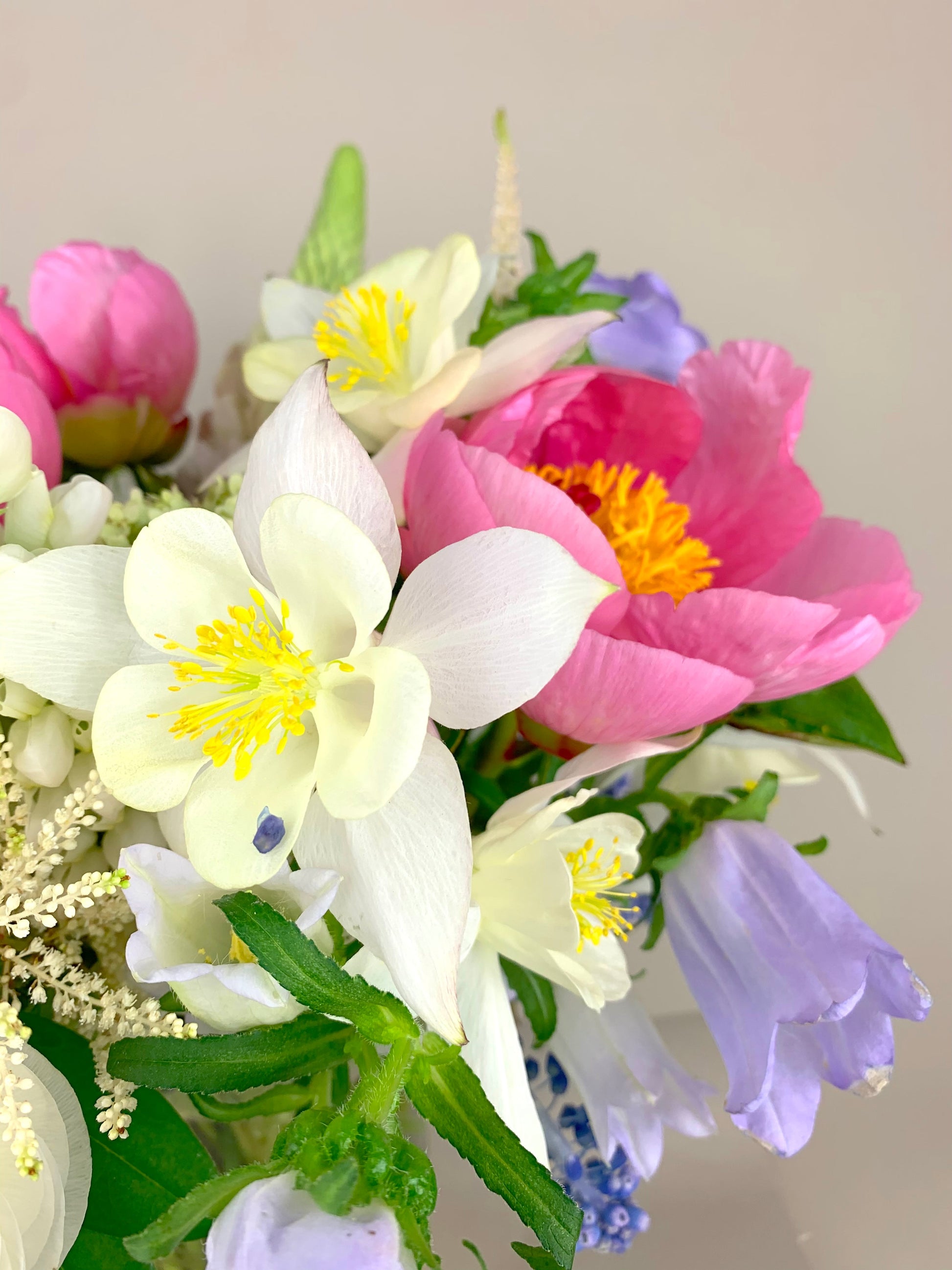 An arrangement of COLORFUL flowers in a vase on a table.