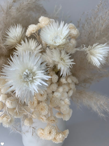 White ETERNAL dried flowers in a vase on a table that adds an artistic flair to any room from TAKAYASATO.COM.