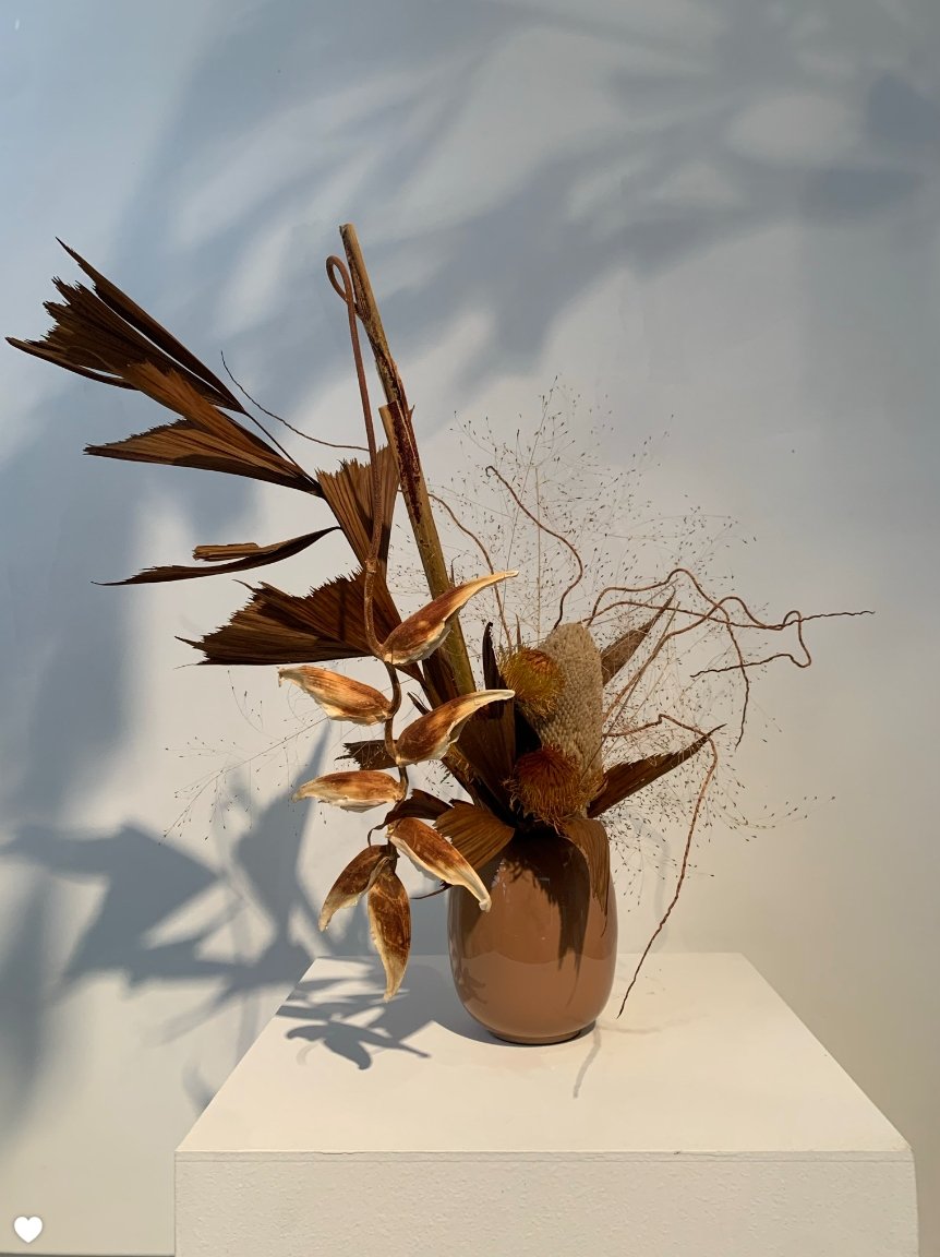 An Takayasato.com Eternal vase adorned with brown leaves, showcasing an artistic flair.
