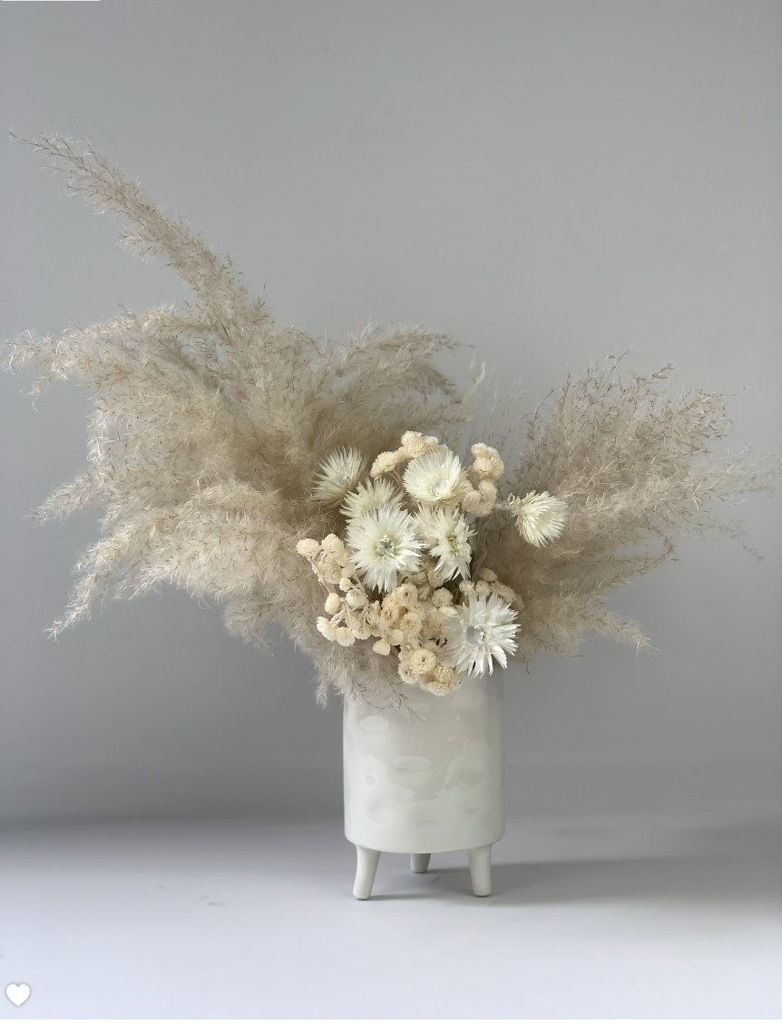 An Eternal Arrangement of dried grasses in a white vase by TAKAYASATO.COM.